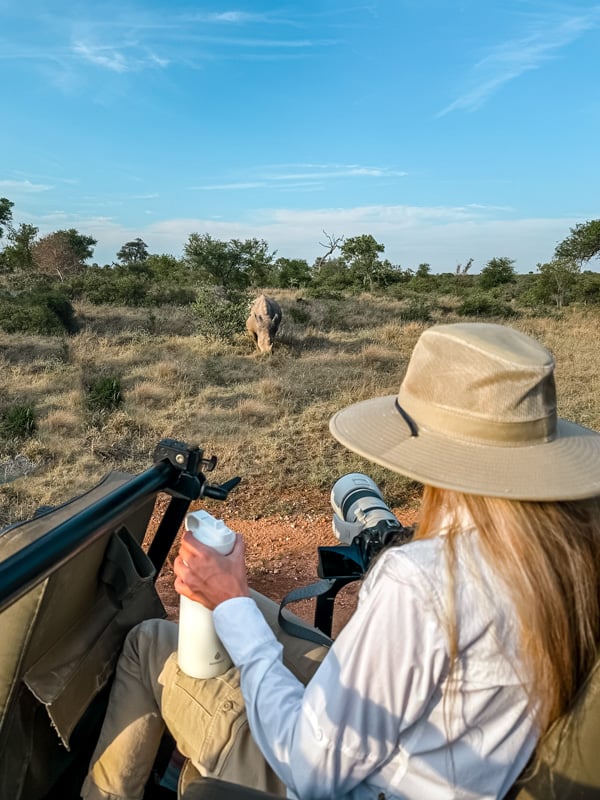 Sam taking photos of Rhino holding water bottle.