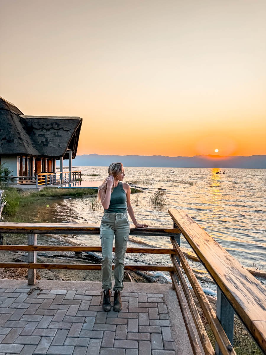 Sam standing in front of Lake Manyara wearing olive green pants and an olive green shirt.